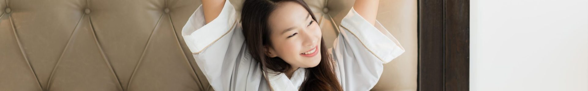Portrait beautiful young asian woman wake up with happy relax and smile on bed in bedroom interior